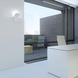 App 2 Light Aluminium LED Wall Light in white, curved panel design mounted on an office wall near a glass door, with integrated LED glow visible above and below.