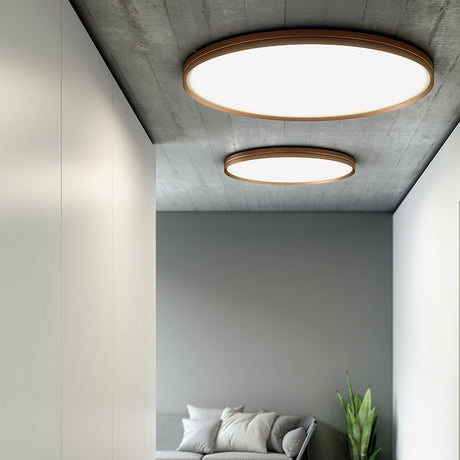 Two round Lite Hole C 120 LED ceiling lights with gold-tone twin-ring rims and white diffusers, installed in a hallway with concrete-effect ceiling.