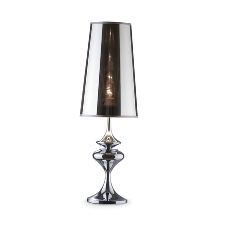 The Alfiere Large Table Lamp - Chrome features a sleek, reflective metal base and a tall, metallic silver shade. When turned on, this modern lamp casts a soft glow that enhances its contemporary lighting appeal.