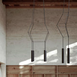 Rose Square 4 Light Cluster Chandelier in matt black, with stacked square wire frames and four cylindrical GU10 shades, shown hanging against a textured wall in a wood-beamed interior.
