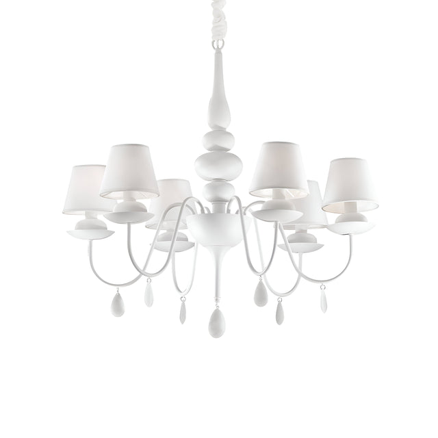 The Wisp 6 Light Chandelier in white showcases a sophisticated design featuring six lampshades and intricately curved arms, embellished with teardrop-shaped ornaments. Its stunning white finish is elegantly suspended from a single chain.