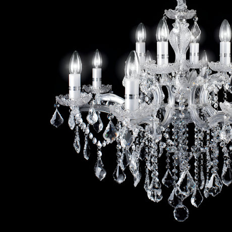 A close-up of the Aurora Crystal 12 Light Chandelier - Chrome against a black background reveals its elegance. This chandelier features multiple arms embellished with hanging crystal beads and teardrop-shaped pendants, all in polished chrome. When fully illuminated, it produces a captivating sparkling effect.