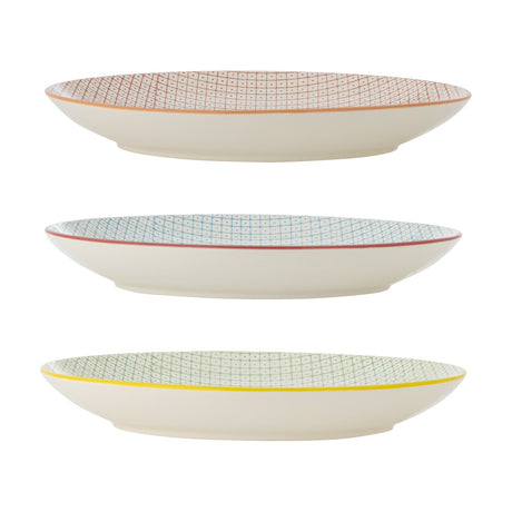 Carla ceramic dinner plates in three assorted designs, each with a fine dotted grid pattern and coloured rim in orange, red, or yellow, shown side-on against a white background.