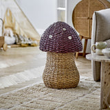 Corintha Mushroom Seagrass Basket with Lid in brown, with a woven domed cap and spotted pattern on a sturdy stem base, shown in a living room setting.