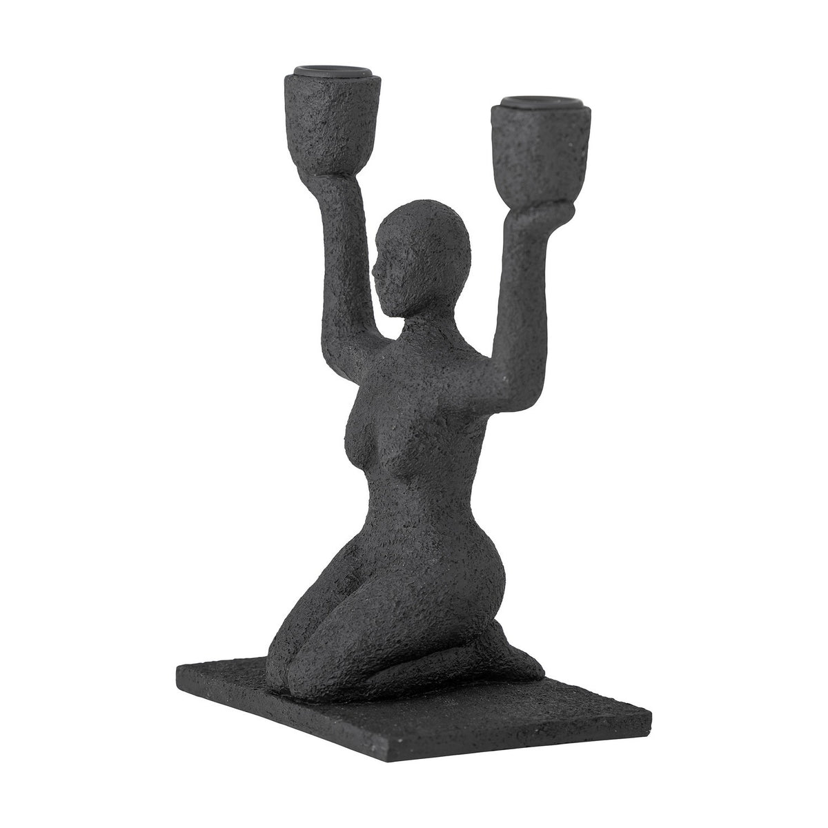 Lucie Resin Candle Holder in black, a textured kneeling female figure raising both arms to hold two cup-shaped candle sockets, on a rectangular base against a white background.