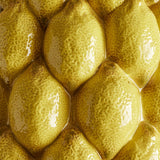 Close-up of the Limone Stoneware Vase 22cm in yellow, showing glossy raised lemon forms with dimpled, speckled ceramic texture covering the surface.