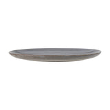 Side view of the Sandrine Stoneware Dinner Plate in grey, showing its low flat profile and raised rim with a reactive speckled glaze, against a plain white background.