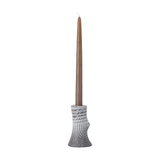 Raheem Stoneware Candle Holder in grey, 13cm tall with a branch-like, ridged textured body holding a tall brown taper candle, shown against a plain white background.