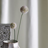 Phlox Artificial Stem in cream, showing two fluffy round flower heads on slender green stems in a textured ceramic vase against a softly blurred neutral backdrop.
