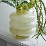 Sahara Glass Vase 22cm in Yellow, a mouthblown ribbed glass vase with stacked rounded tiers and glossy finish, shown holding greenery on a windowsill.