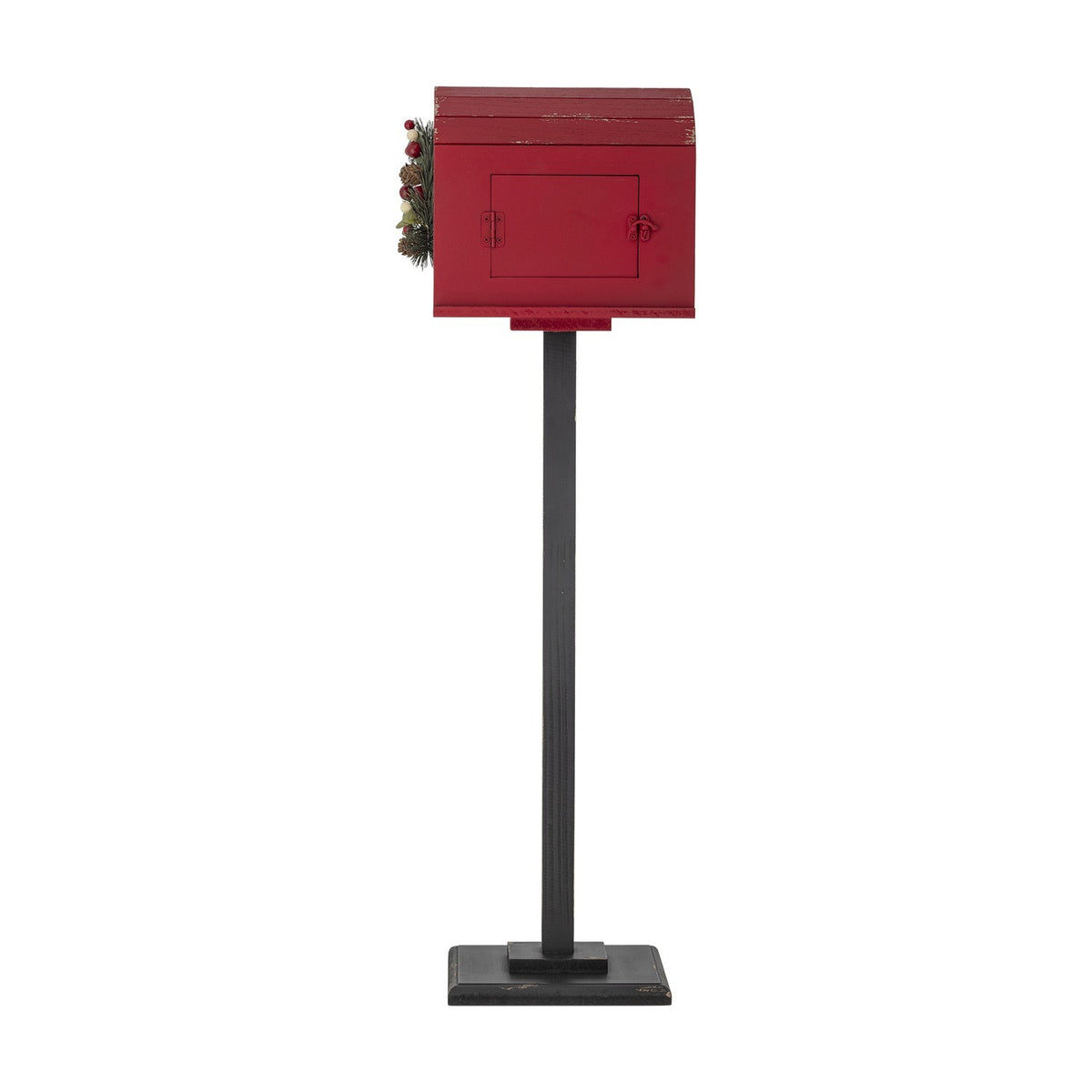 Red MDF Carlo Christmas postbox decoration with black stand, curved slatted roof, latching front door, and pine wreath with berries, shown on a white background.