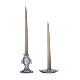 Linley Fish Glass Candle Holders in blue, one upright fish-shaped holder and one flat fish dish, each holding a tall taupe taper candle on a plain white background.