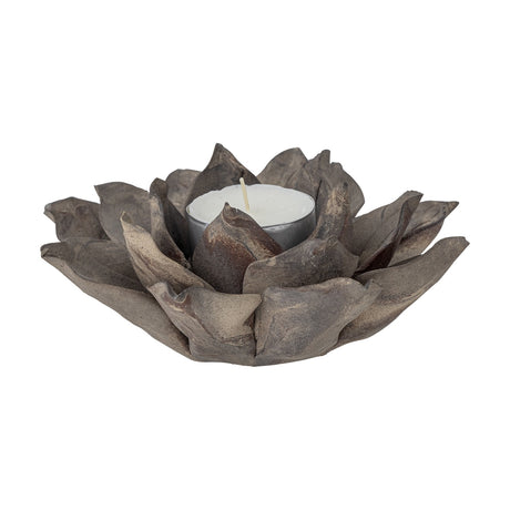 Eira Flower Stoneware Tealight Holder in brown, shaped like an open flower with layered pointed petals and curled inner petals cradling a lit tealight, shown on a white background.