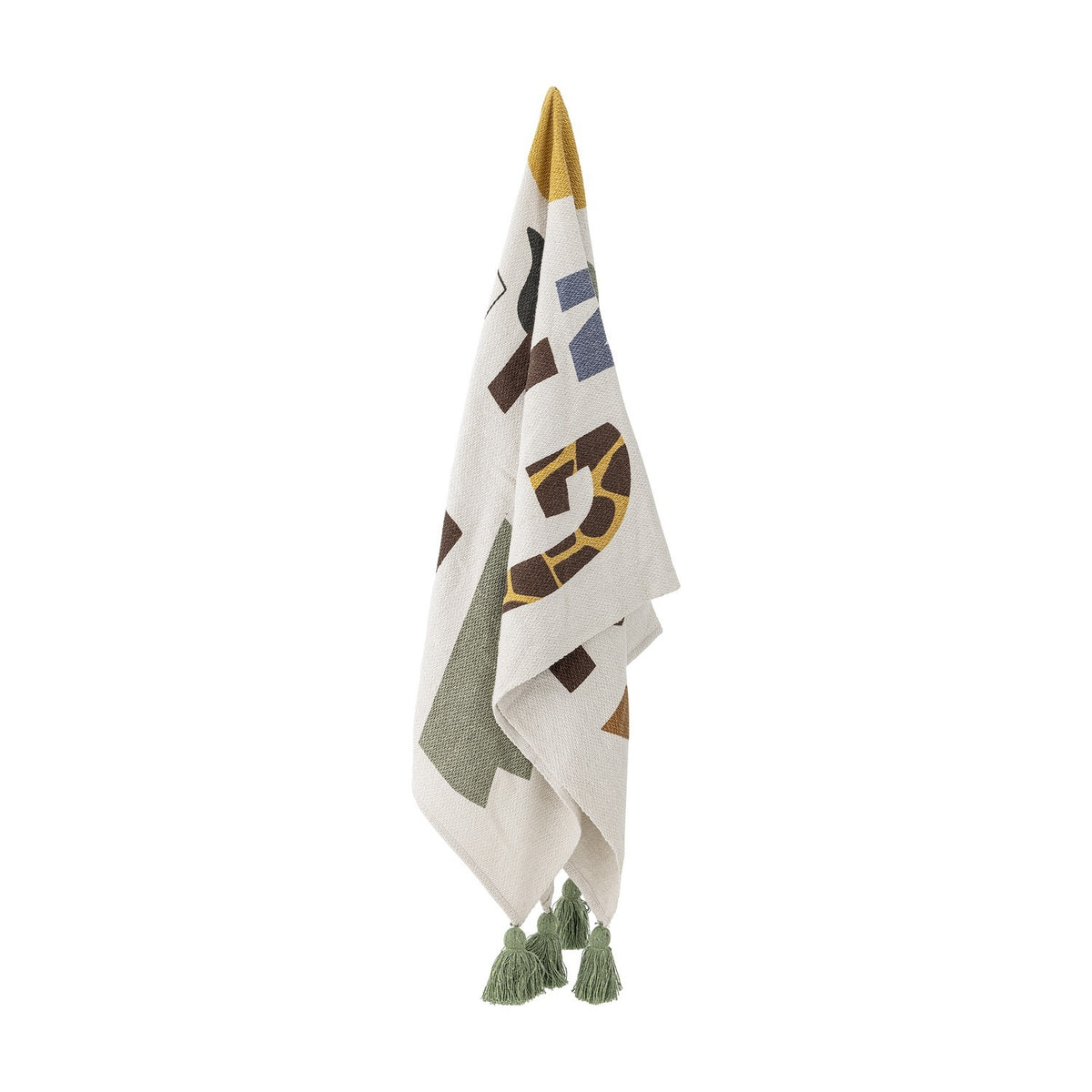 Memmo Cotton Throw in multicoloured cotton, hanging with bold abstract letter shapes in green, mustard, brown and blue, finished with green tassels, on a plain white background.