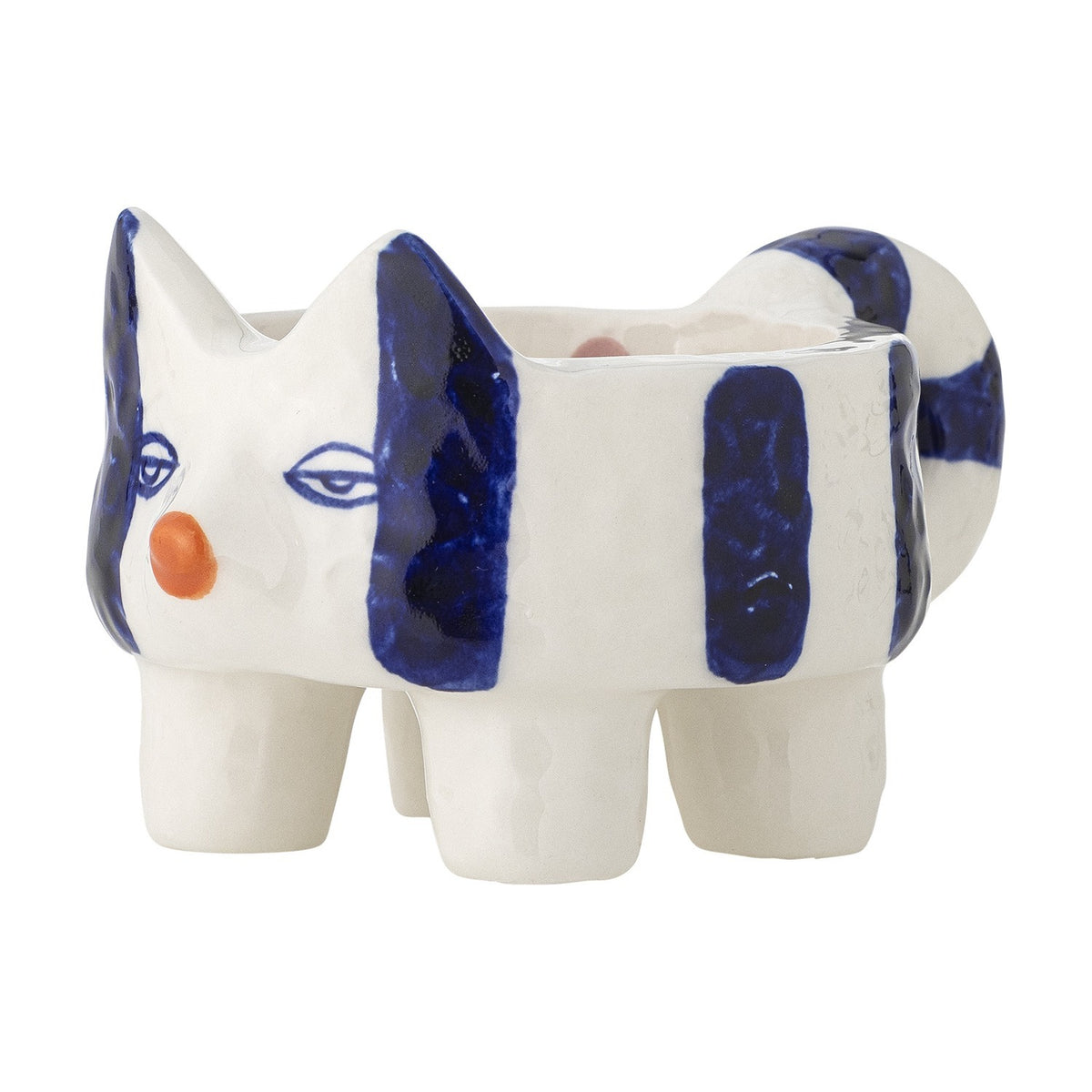 Caty stoneware candle holder shaped as a striped cat with pointed ears, drawn eyes, orange nose, four legs, and a curled tail forming a handle, in white and blue ceramic on a plain background.