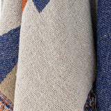 Clarita Cotton Throw in Multi, close-up of woven cotton fabric showing cream, blue and orange geometric pattern with fringed edge detail.