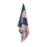 Cadeo cotton throw in blue with wide diagonal beige stripes and fringed edges, hanging against a plain white background.