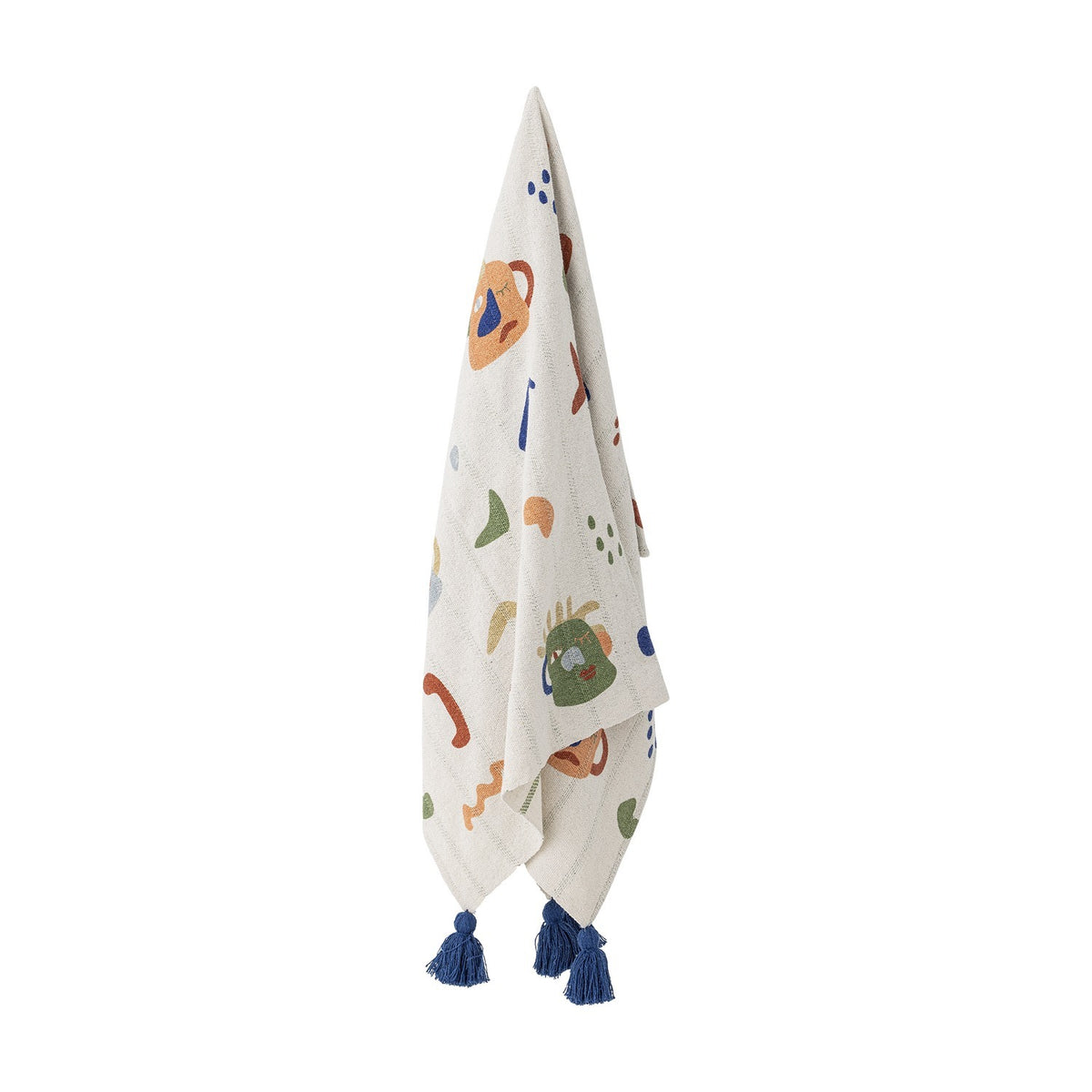 Sylvie Cotton Throw in Multi, a kids' cotton-blend blanket printed with abstract jug-like faces, dots and squiggles, finished with navy tassels, hanging against a plain white background.