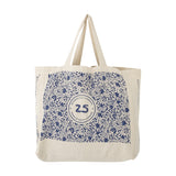 Beige cotton shopping bag with twin handles, printed with small blue motifs around a round 25 anniversary emblem and side lettering, shown on a white background.