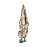 Filur Cotton Throw in multicoloured abstract print with green tassel corners, shown draped against a plain white background.