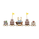 Wooden birthday train with five linked wagons featuring a cat, tiered cakes with yellow pennant flags, a dachshund carrying a number and gift, and a small animal, in multicoloured MDF finish.