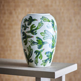 Birdliva Stoneware Vase 33cm in white with a green and blue bird-in-flight pattern, rounded shoulders and short rim, displayed on a wooden table against a woven backdrop.