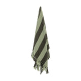 Frello Striped Cotton Throw in Green, hanging to show broad diagonal stripes and knotted tassel fringe, against a plain white background.