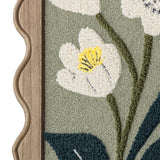 Talan Wavy Framed Print close-up showing tufted white flower with yellow centre, green stems and dark leaves on sage background, set in a wavy-edged wooden frame.