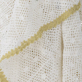 Close-up of the Rovigo Cotton Throw in natural white, showing an open lacy crochet weave with a contrasting yellow scalloped edge detail.