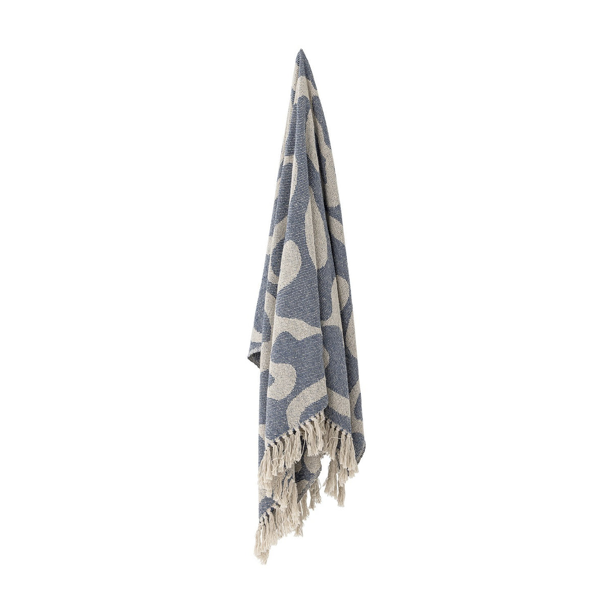 Salobre Cotton Throw in blue, woven with large abstract shapes in a lighter tone, finished with knotted fringe and hung against a plain white background.