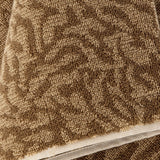 Close-up of the Kaysa Cotton Towel in brown, showing a branching coral-like woven pattern in looped cotton pile with a woven trim edge.