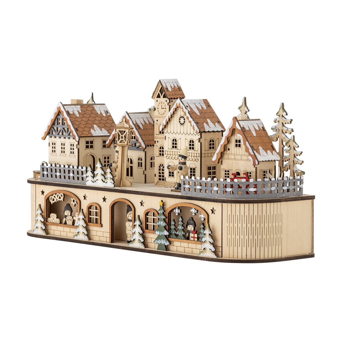 Norwich Wooden Christmas Decoration with Light in beige, a lit miniature village scene with gabled snow-capped houses, clock tower, fir trees and tiny figures, set on a plain white background.
