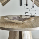 Aiku Shell Glass Bowl 38x29cm in pearl with rippled, shell-like rim, shown on a round wooden table beside sculptural candle holders.