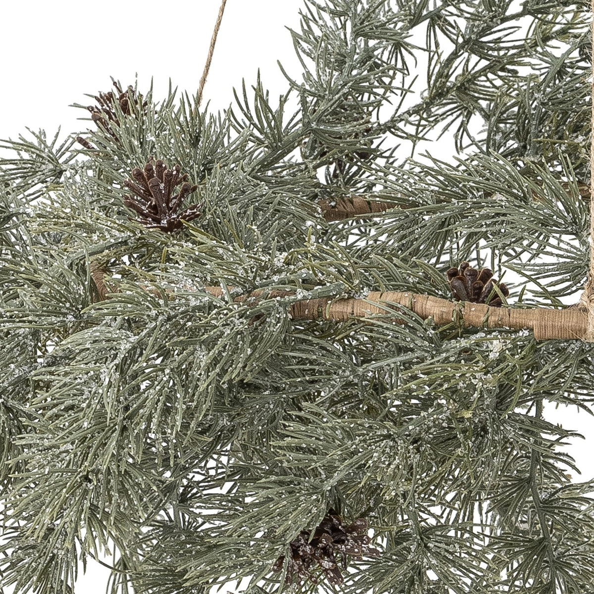 Close-up of the Cedar Artificial Christmas Wreath 70cm in green, showing frosted faux pine needles, small brown cones, and a twine-wrapped branch against a white background.
