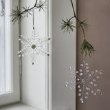 Miku Snowflake Christmas Tree Decorations, set of 2 clear beaded wire snowflakes, hanging from pine branches with one faceted centrepiece and one beaded cluster centre.