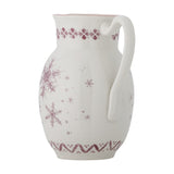 White stoneware Christmas jug with rounded body, pouring lip, and looped handle, decorated with pink-toned snowflake patterns and patterned borders, on a plain white background.