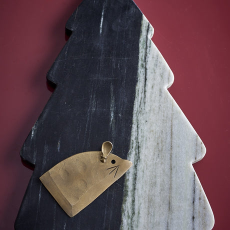 Diya Christmas Tree Marble Chopping Board in black, with stepped tiers and natural veining, shown with a brass mouse-shaped cheese knife on a dark red background.