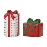 Marnia ceramic salt and pepper shakers shaped as gift boxes, one tall white box with red dashes and bow, one wide red box with green dots and bow, on a white background.