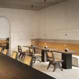 Rendez-vous Cone LED Pendant Light in matt black, small cone shades on fine cables above dining tables with cane chairs and tan banquette seating.