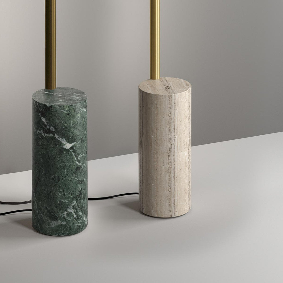 Hilow Line floor lamp base in Alps Green marble with brushed brass rod, shown beside a travertine version on a neutral grey background.