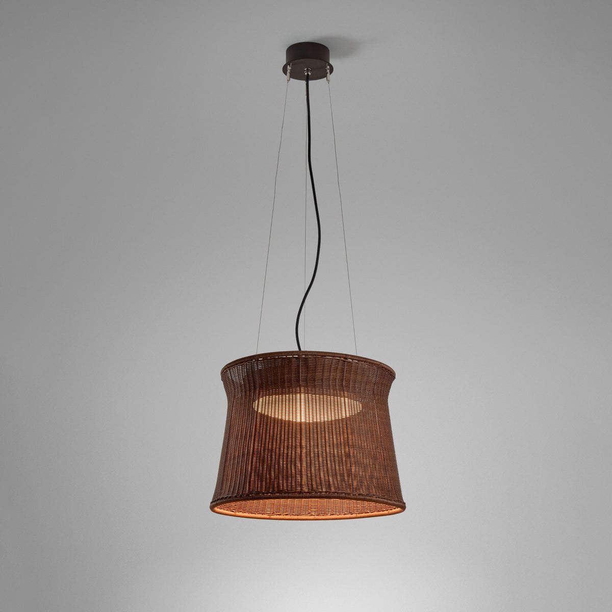 Syra 45 pendant light with a woven brown drum shade narrowing at the waist, suspended on three wires and a central cable from a round canopy, against a plain grey background.