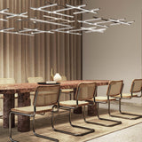 Hilow White Diffuser Frame LED pendant light with crossed linear bars in silver finish, shown above a dining table in a modern living space.