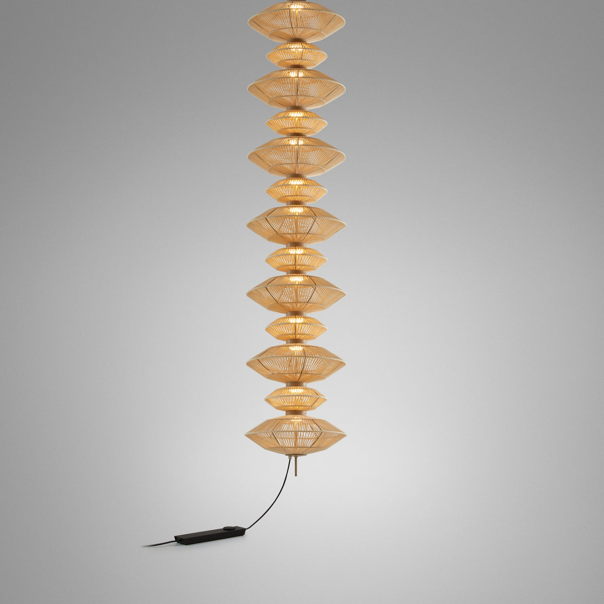 Yuyun S/13C fabric LED pendant light, a tall column of thirteen woven satin beige tiers on a single cable with visible warm-white glow, shown against a plain grey background.