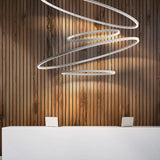 Brooklyn Round 360° Aluminium Ring LED Pendant Light in white, multiple tiered circles suspended above a reception desk against a wood-slat wall.