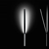 Ypsilon Recessed LED Wall Light in chrome, a slim angled blade fixture casting a soft warm-white glow on a dark background.