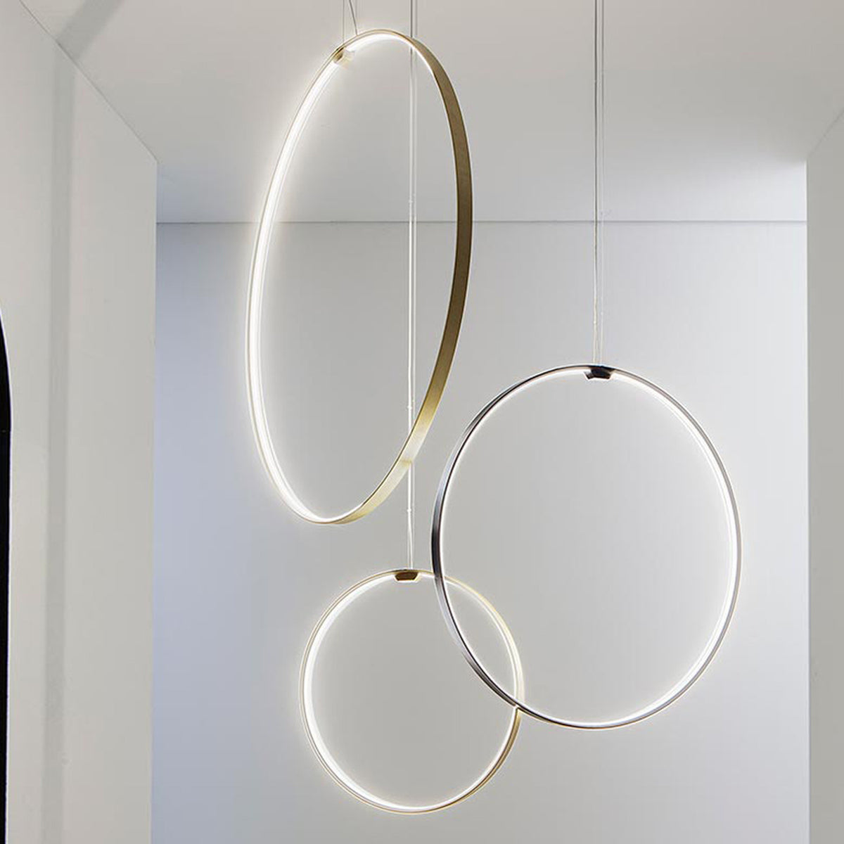 Zero Round Vertical Ring Pendant Light, 74cm circular rings in brushed brass and silver finishes with integrated LED, shown suspended in a white interior.