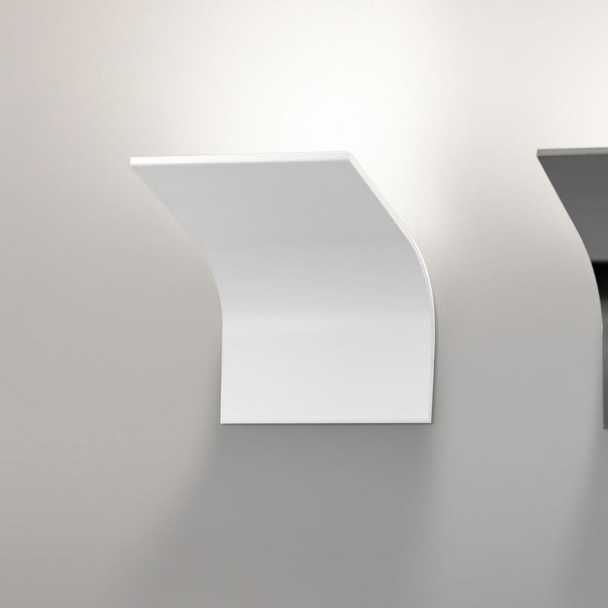App 2 Light Aluminium LED Wall Light in white, a curved panel fixture mounted on a plain wall, casting soft ambient light upward and across the surface.