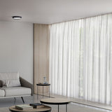 Beaded C round flush ceiling light with black trim and grey glass diffuser, mounted in a neutral living room with sheer curtains and wood panelling.