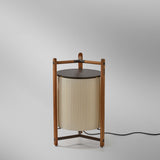 Kando P/76 Ribbon LED floor lamp with a cream pleated cylinder shade, teak wood tripod frame, and brown top disc, shown on a plain light grey background.