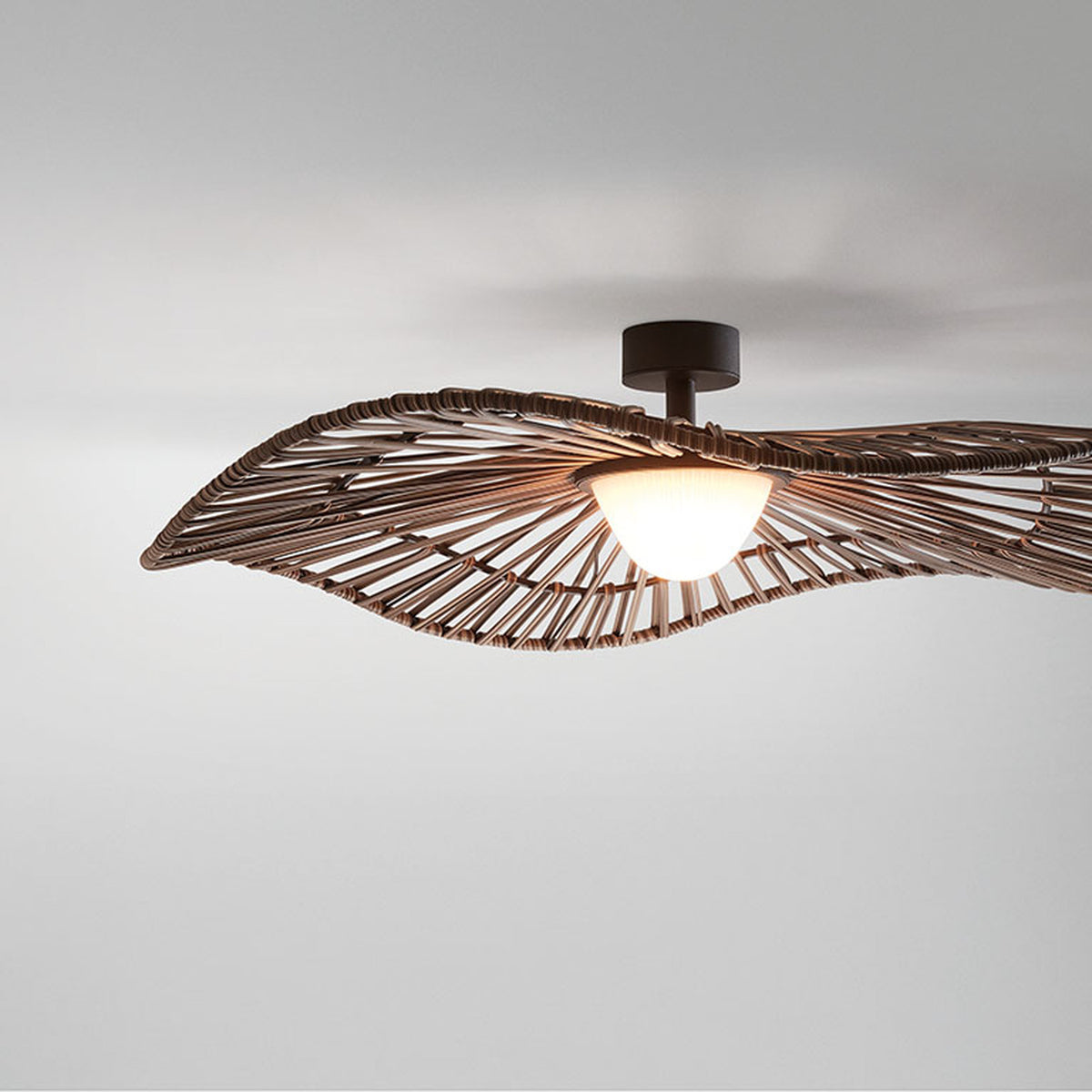 Mediterrània PF/105 outdoor semi-flush ceiling light with a wide, wavy brown woven synthetic fibre disc shade and white rounded diffuser, mounted on a short stem against a plain light background.